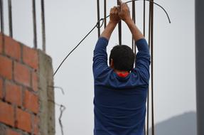 worker holds rebar at a construction site at home