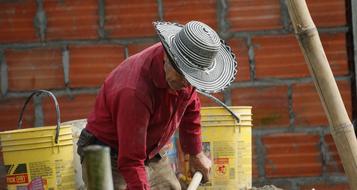 Adult worker man, near the brick wall, in Colombia