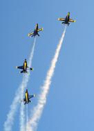 Beautiful, flying, blue and yellow Blue Angels, with white contrails, in blue sky