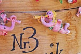 Beautiful and colorful decorations on the wooden wall with house number 3