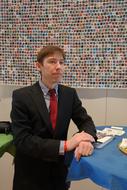 young man in tie suit at trade fair stand