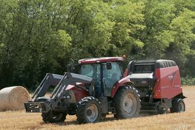 tractor harvests from a rural field