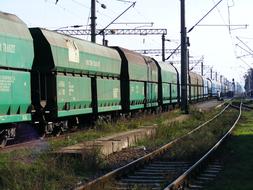 Old, green train, on the railway, among the colorful grass