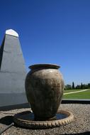 Beautiful, large urn, among the colorful fields with plants, under the blue sky