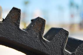 Close-up of the old, metal industrial equipment, at blurred background with the landscape, in light