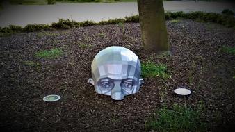 sculpture in the form of a human head on the ground