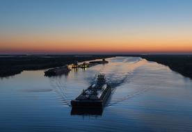 Barges, on the canal, at colorful and beautiful, gradient sunset on horizon, in the evening