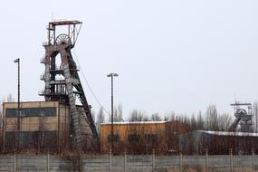 Industrial site for coal mining, among the colorful trees, at gray sky on background