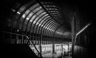 Black and white photo of the stairs, with the ceiling, in the airport