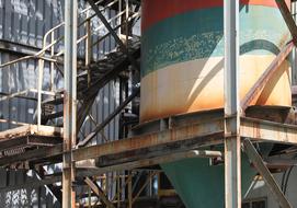 Colorful factory, with the rusty barrel, near t he stairs, in light and shadow