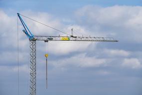 Close-up of a crane, at beautiful blue sky with white clouds on background