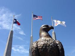 metal sculpture of an eagle on the background of american flags