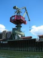 Colorful loading crane, at blue sky with white clouds on background