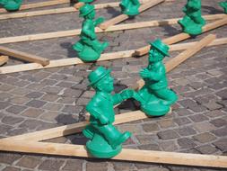 art project in the form of green figures of men on the street