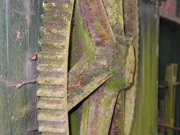 rusty metal mill wheel on the wall