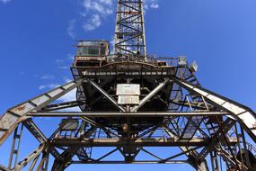 Low angle shot of the metal crane in sunlight, under the blue sky with white clouds, in Bakar, Croatia