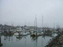 Colorful boats on the water, with reflections, in the harbor, under the clouds