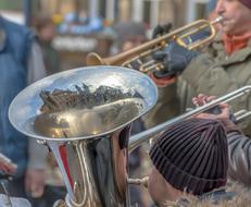 Street musicians, playing on the beautiful, shiny wind instruments, in winter