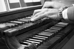 man hands playing organ