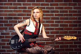 singer with bass guitar on brick wall background