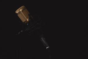 photo of a golden microphone in the dark