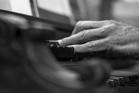 an elderly man's hand on a musical instrument in a church