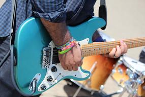 man plays blue electric Guitar