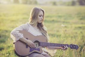 girl playing guitar outside