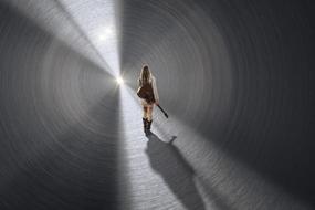 girl with a guitar in a tunnel in the rays of light