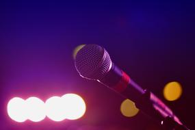 Close-up of the shiny microphone, at colorful bokeh lights on background