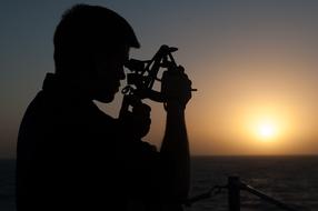 silhouettes of a sailor with a stimeter at dusk