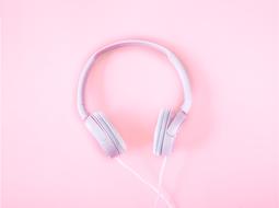 white headphones on a pink background