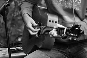 young boy plays guitar, black and white