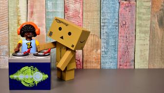 toy DJ and Danbo on the background of a multi-colored wooden wall