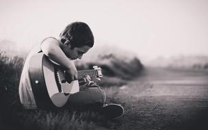 black and white photo of a guitarist on a rural field