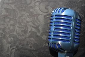 closeup picture of the vintage blue Microphone at grey background