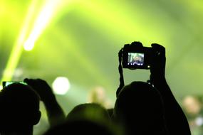 crowd is filming a concert on video