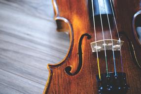 Shining wooden violin on the wooden surface
