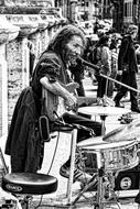 black and white photo of a street guitarist with a drum kit