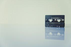 black retro audio cassette on glass table