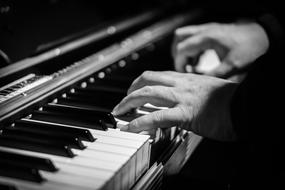 black and white photo of a man playing the piano