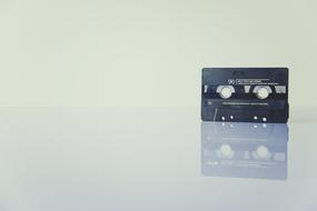 black audio cassette on a glass table