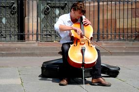 musician plays cello on the street