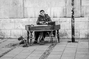 black and white photo of a street musician with a piano