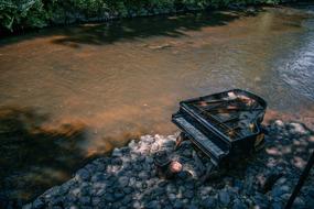 old broken piano by the river