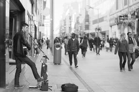 black and white photo of a street musician on a city street