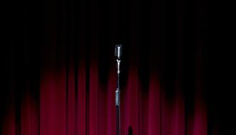 vintage Microphone on stage in front of red Curtain