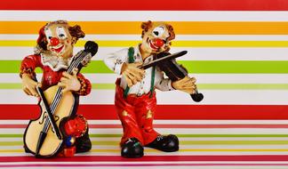 Colorful clown figures playing on musical instrument at background with colorful lines