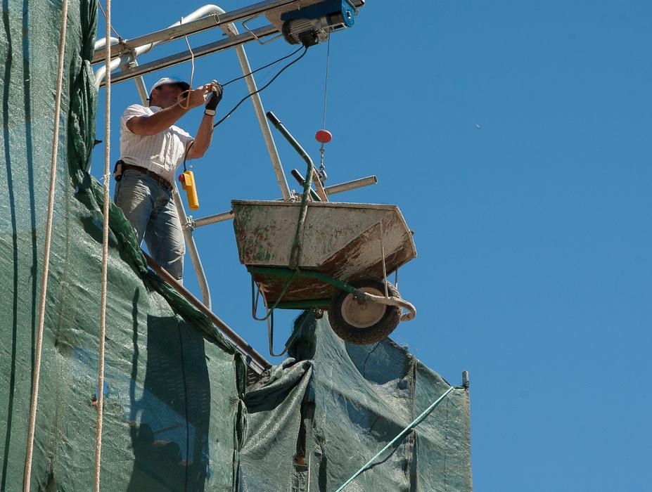 worker with Wheelbarrow on scaffolding