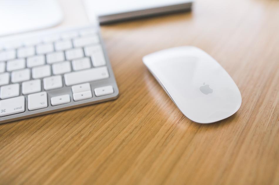 white keyboard and white Apple computer mouse on the wooden surface